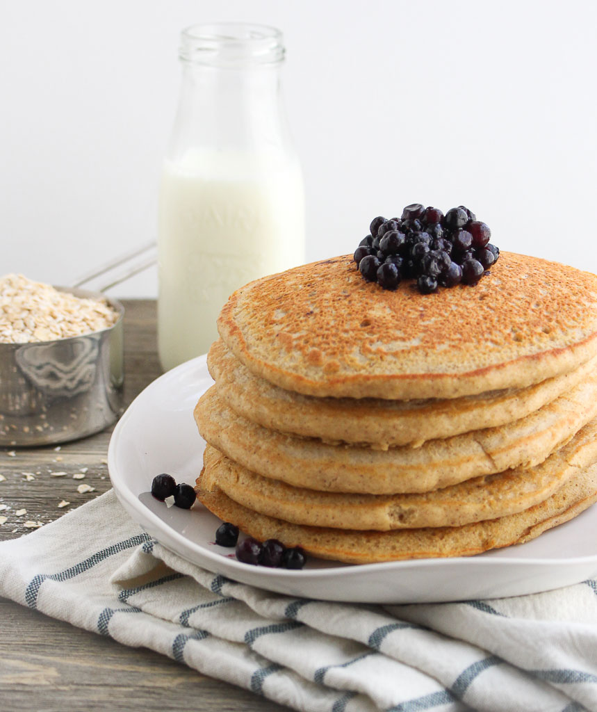 gluten free pancakes on a white plate topped with wild blueberries