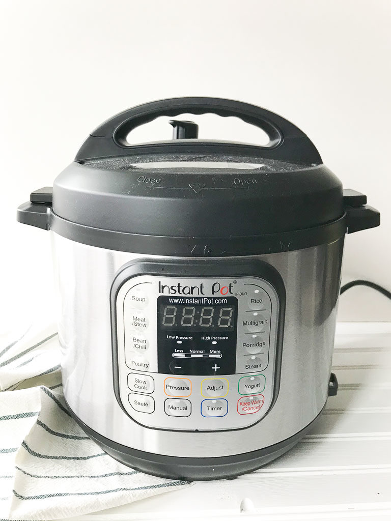 instant pot sitting next to gray striped towel