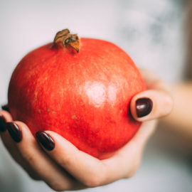 hand holding a pomegranate