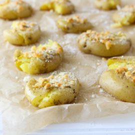 Garlic Parmesan Smashed Potatoes on parchment paper