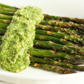 Parsley Stem Pesto over Roasted Asparagus on a white plate