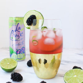 Blackberry Lime Fizz in a tall glass with gold bottom
