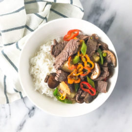 pineapple beef stir fry with white rice in a white bowl