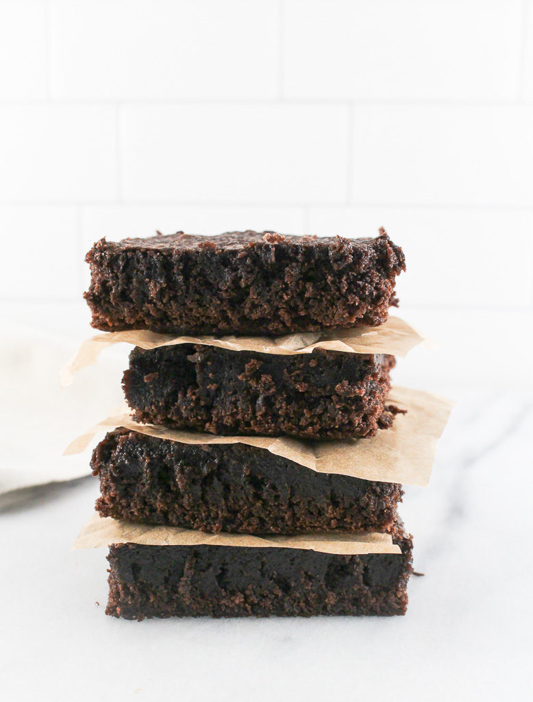 brownies stacked on top of each other divided by parchment paper