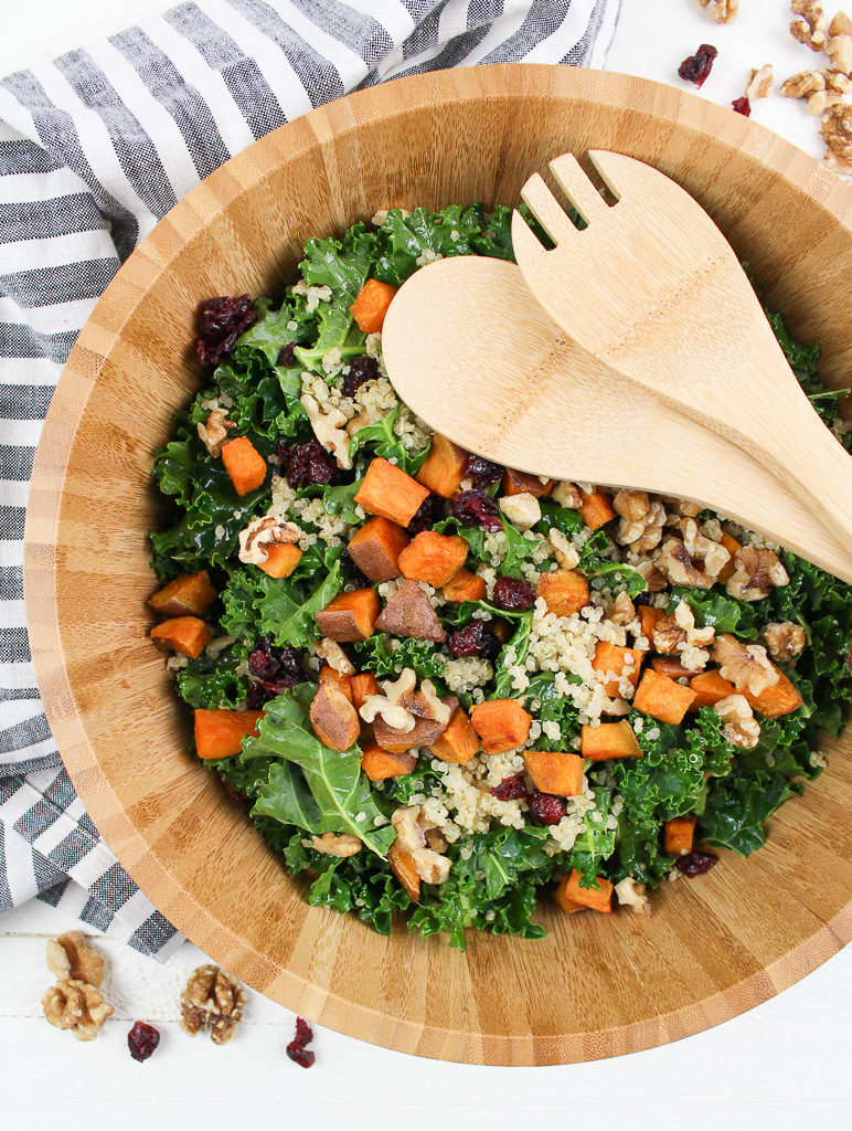 Roasted Sweet Potato Kale Salad in wooden bowl with wooden serving spoons
