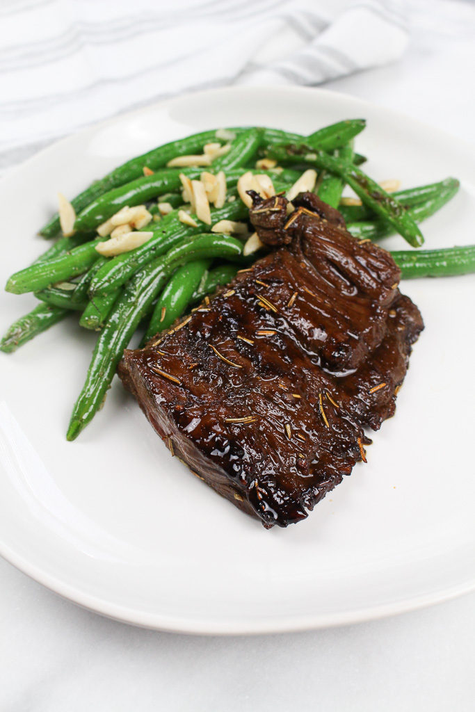 Balsamic Marinated Strip Steak with green beans on a white plate