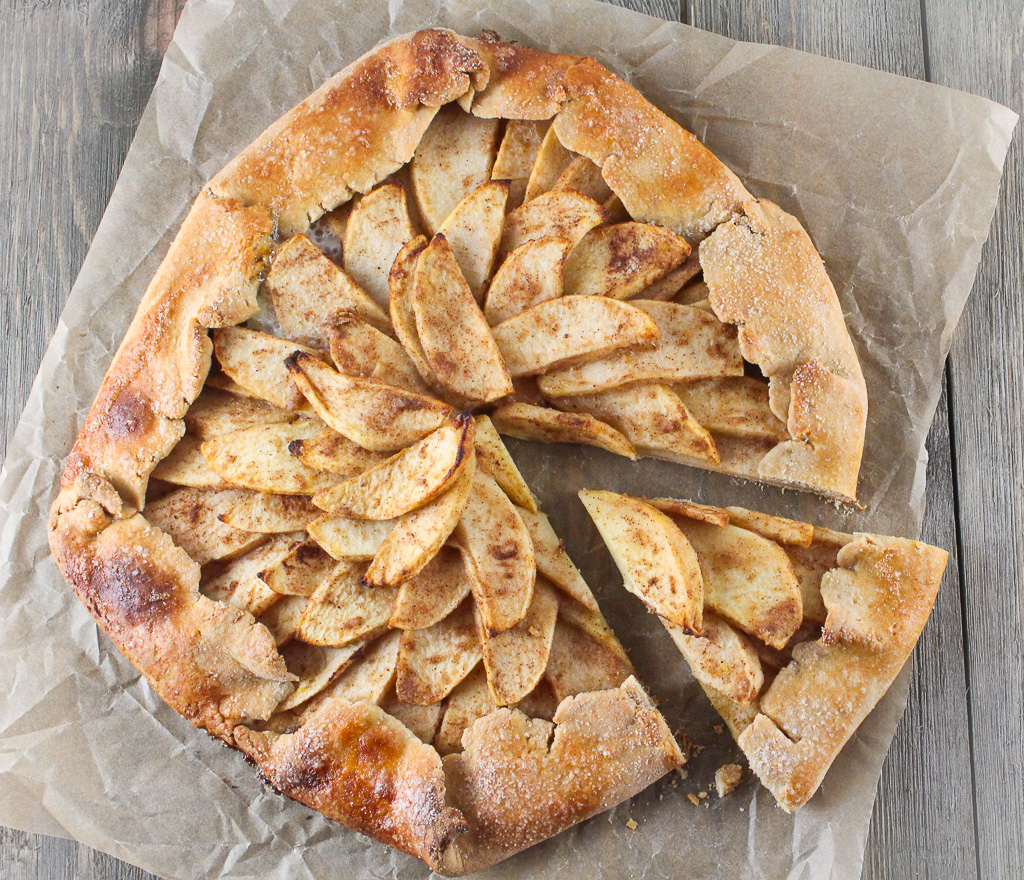 full apple galette on a piece of parchment paper with a slice cut out