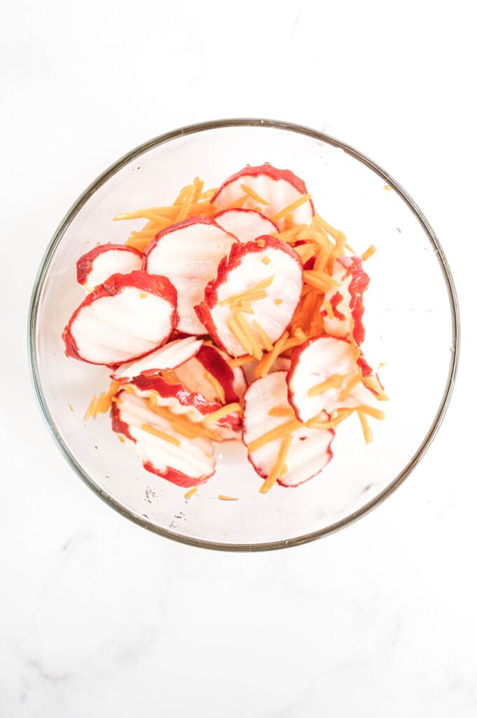 glass bowl with sliced radishes and shredded carrots