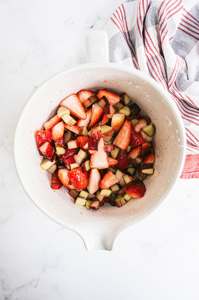 diced strawberries and rhubarb in a white mixing bowl